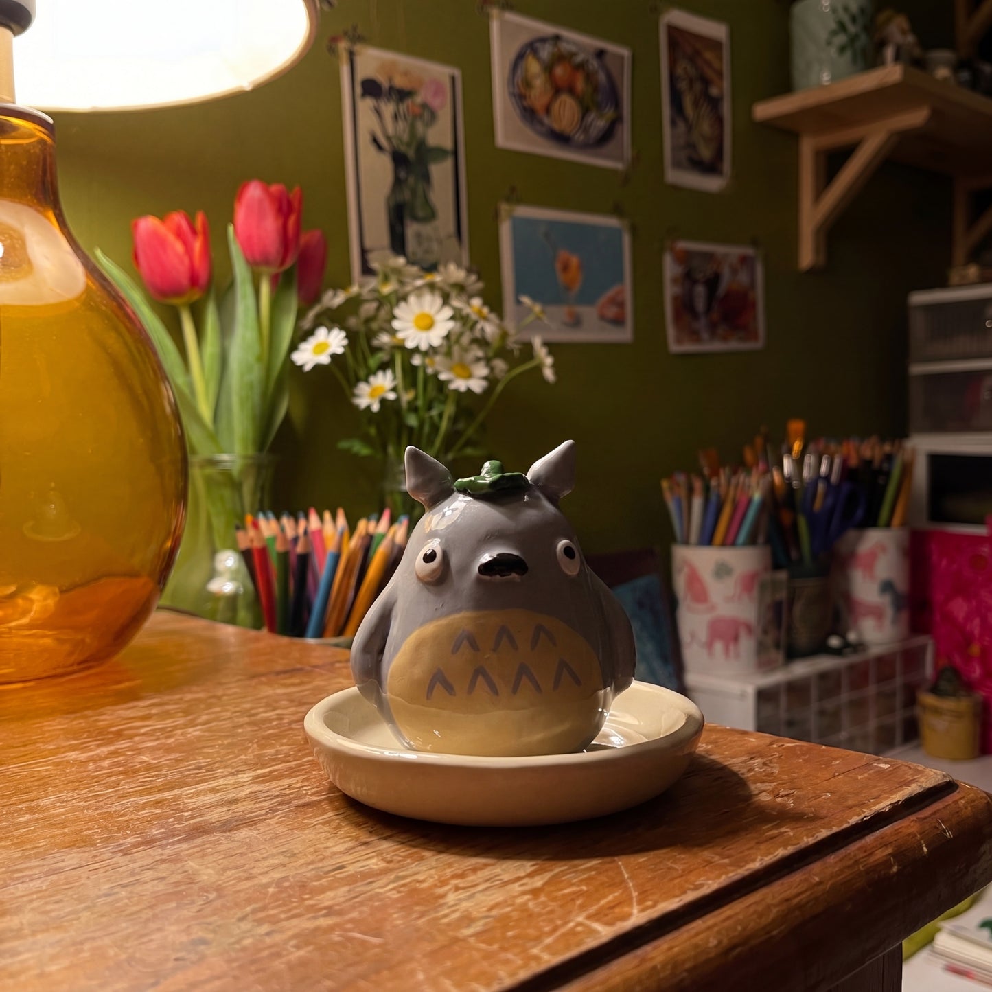 Forest Spirit handmade glossy clay desk pal, in the Moon Kiln studio, evening lamp light