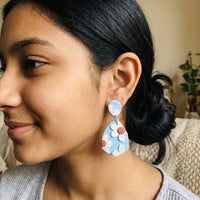 Daisy Blue handmade polymer-clay earrings, worn on the ear