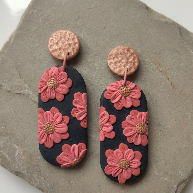 Cherry Blossoms handmade polymer-clay earrings, the pair on a warm stone surface