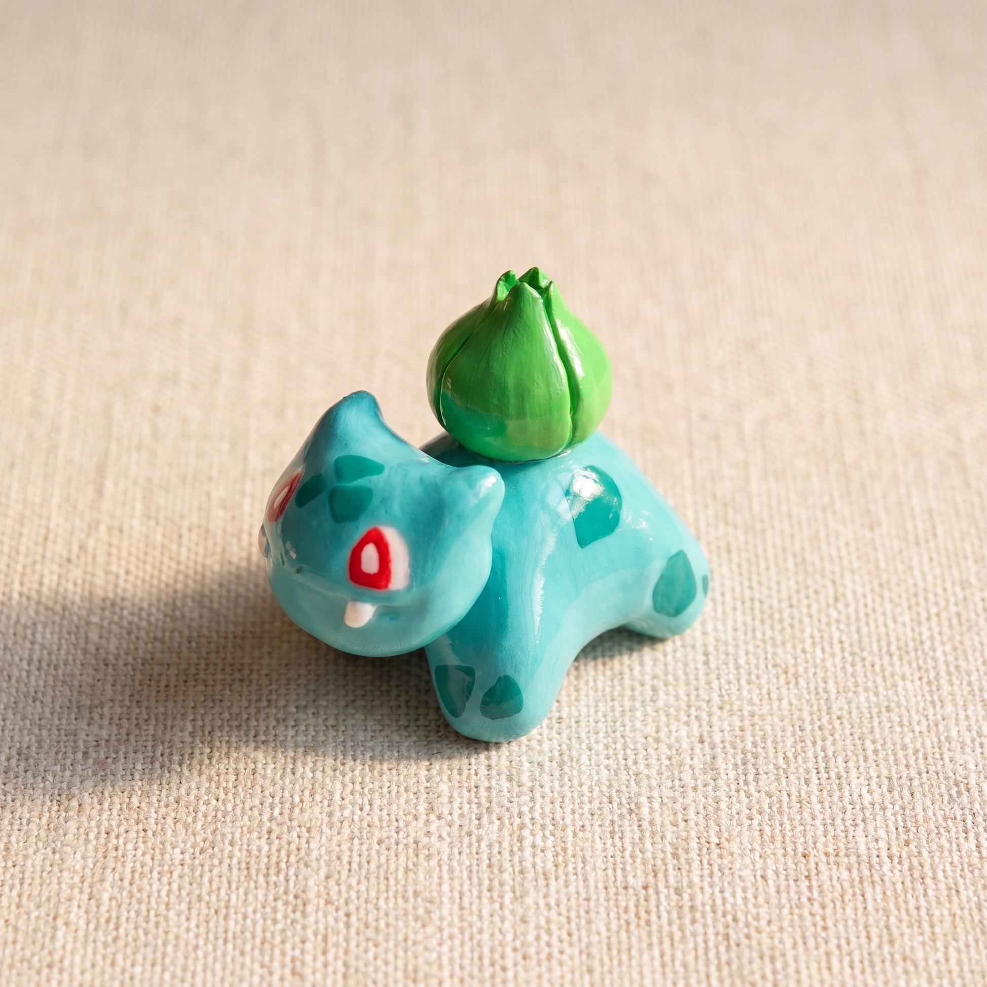 Seed Dinosaur handmade glossy clay desk pal, isometric view