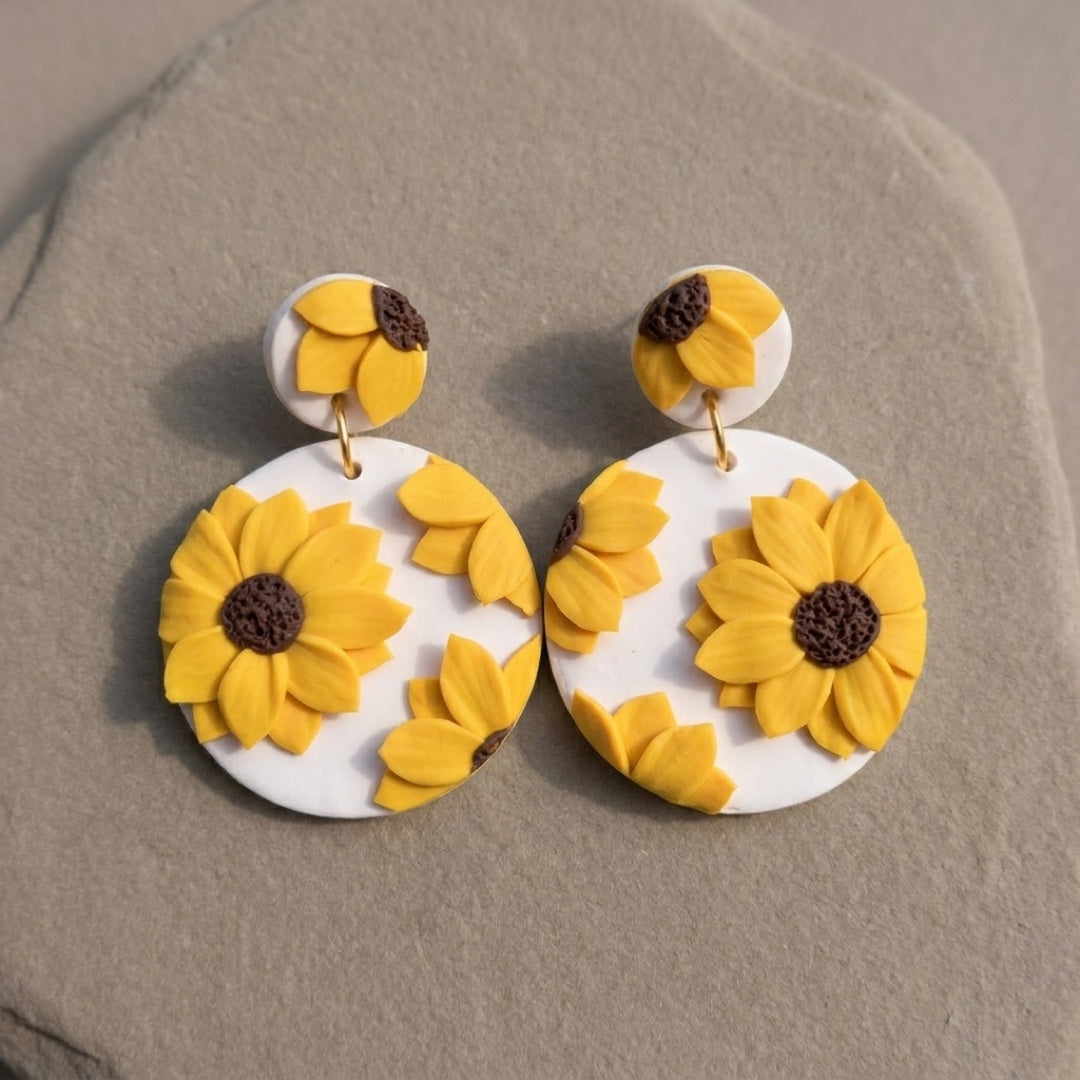 Sunflower Dangles handmade polymer-clay earrings, the pair on a warm stone surface