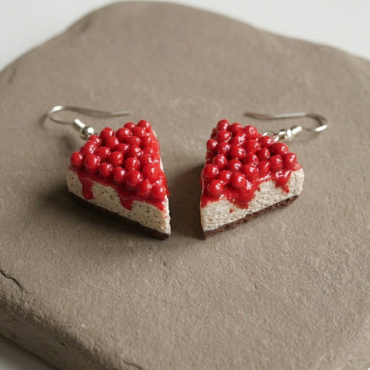 Cherry Cheesecake handmade polymer-clay earrings, the pair on a warm stone surface