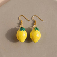 Lemonita handmade polymer-clay earrings, the pair on a warm stone surface