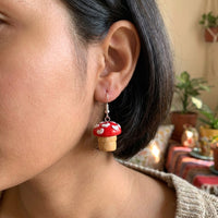 Shroom hearts handmade polymer-clay earrings, worn on the ear