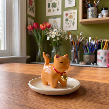 Ginger kitty handmade glossy clay desk pal, styled in the Moon Kiln studio, daytime
