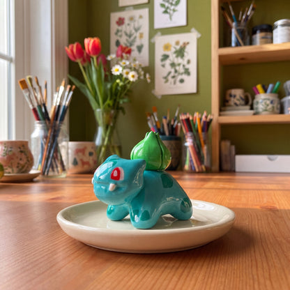 Seed Dinosaur handmade glossy clay desk pal, styled in the Moon Kiln studio, daytime