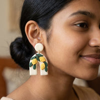 Lemon Botanica handmade polymer-clay earrings, worn on the ear
