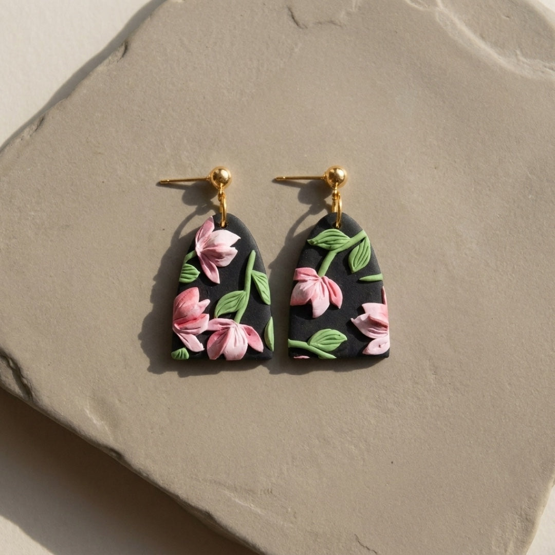 Roseate Drops handmade polymer-clay earrings, the pair on a warm stone surface
