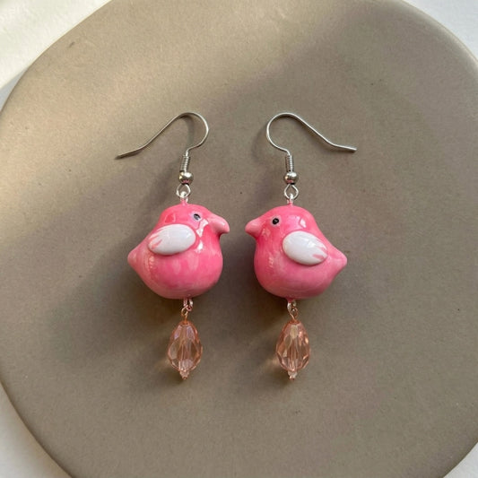 Love at first chirp earrings handmade polymer-clay earrings, the pair on a warm stone surface