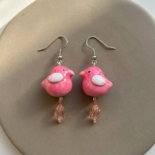 Love at first chirp earrings handmade polymer-clay earrings, the pair on a warm stone surface