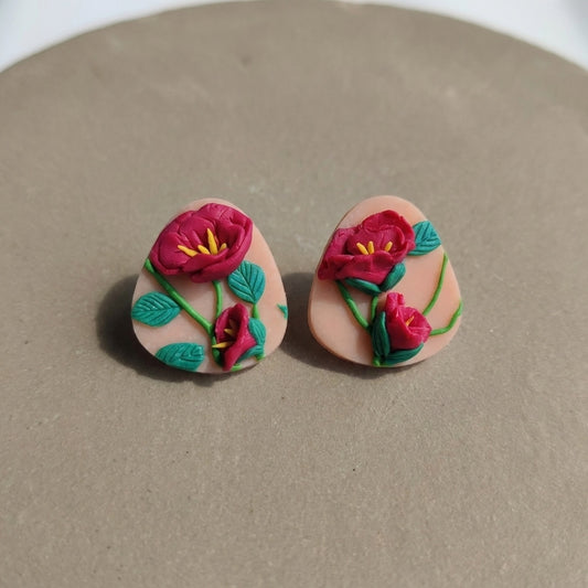 Peony Studs handmade polymer-clay earrings, the pair on a warm stone surface