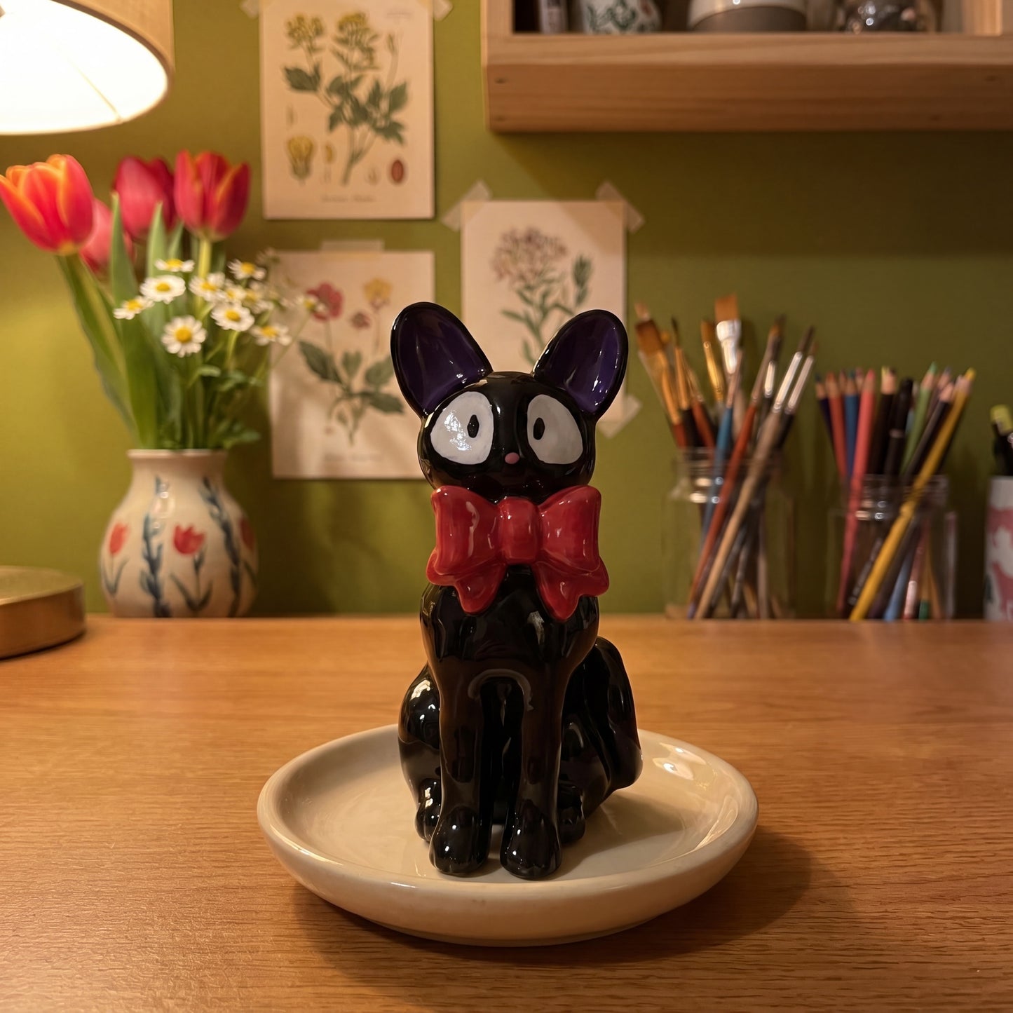 Midnight Cat clay figurine in the Moon Kiln studio, evening lamp light