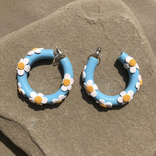 Daisy Blue Hoops handmade polymer-clay earrings, the pair on a warm stone surface