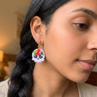 Skull and Flora handmade polymer-clay earrings, worn on the ear