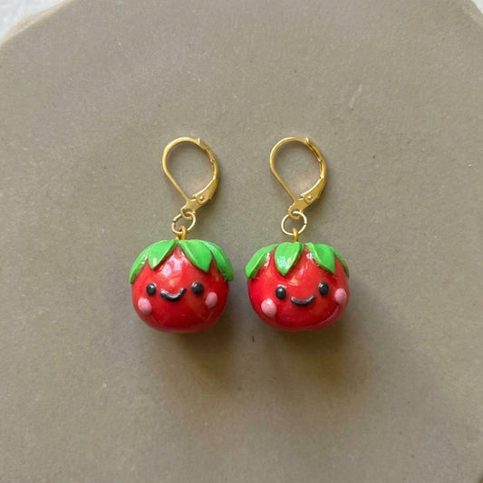 Tomatoes handmade polymer-clay earrings, the pair on a warm stone surface