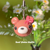 Bear Charm handmade polymer clay phone charm, rosy brown bear head with pink ribbon bow and glossy finish, on silver clasp cord