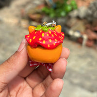 Sir Berryface polymer clay charm, three-quarter view showing fox charm with strawberry cap and ribbon scarf