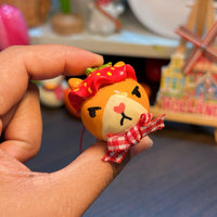 Sir Berryface polymer clay charm, in-hand close-up showing fox face with strawberry hat and gingham bow detail