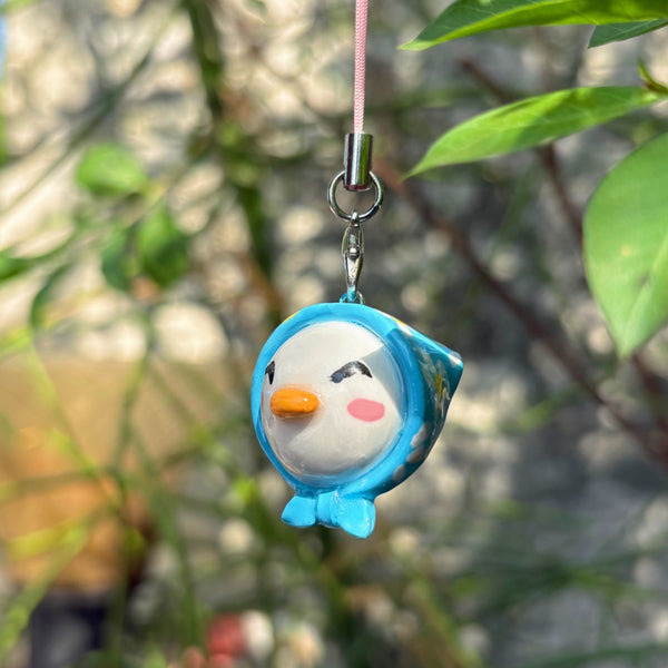 Blue Hooded Bird handmade polymer clay charm, round white bird face with blue hoodie, orange beak, and rosy cheeks, on silver cord