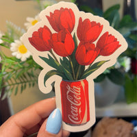 Tulip cola vinyl sticker, flat-lay showing illustrated red tulips sprouting from cola can, die-cut sticker with white border