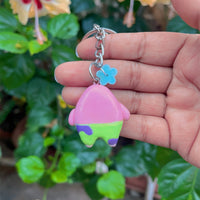 Pink Starfish polymer clay keychain, front view showing chubby pink body with sleepy expression and colourful shorts