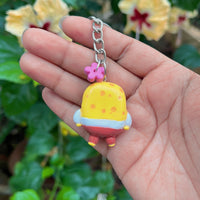 Yellow Sponge polymer clay keychain, back view showing yellow spotted body with red trousers and small yellow feet