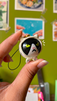 Grumpy Babushka handmade polymer clay charm held in hand, close-up showing scowling cat face detail with floral body