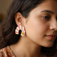 Daisy Bend handmade polymer-clay earrings, worn on the ear