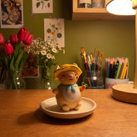 Sunny Bunny handmade glossy clay desk pal, in the Moon Kiln studio, evening lamp light