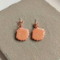 Cordelia’s Blush handmade polymer-clay earrings, the pair on a warm stone surface