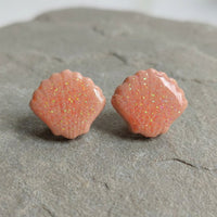Seashell Studs handmade polymer-clay earrings, the pair on a warm stone surface
