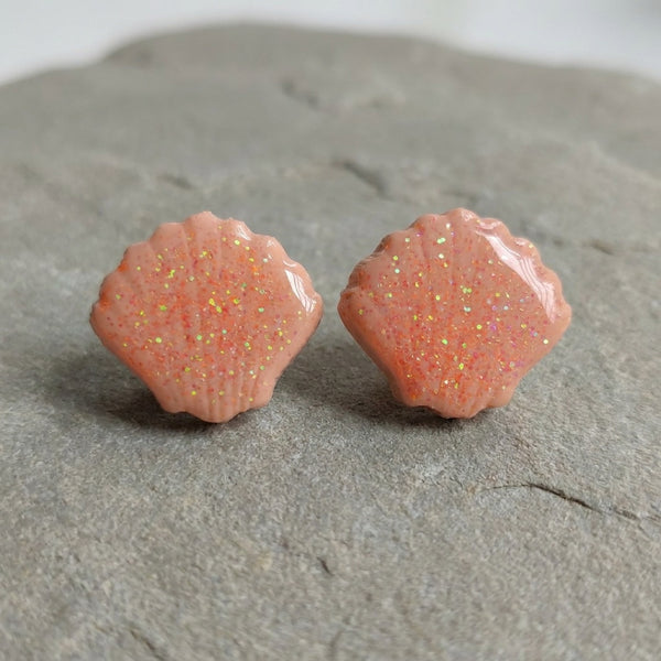 Seashell Studs handmade polymer-clay earrings, the pair on a warm stone surface
