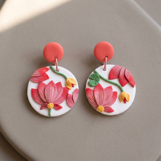 Pink Tipped Lotus handmade polymer-clay earrings, the pair on a warm stone surface