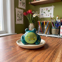 Mr. Ribbit handmade glossy clay desk pal, styled in the Moon Kiln studio, daytime