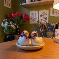 Happy Duck handmade glossy clay desk pal, in the Moon Kiln studio, evening lamp light