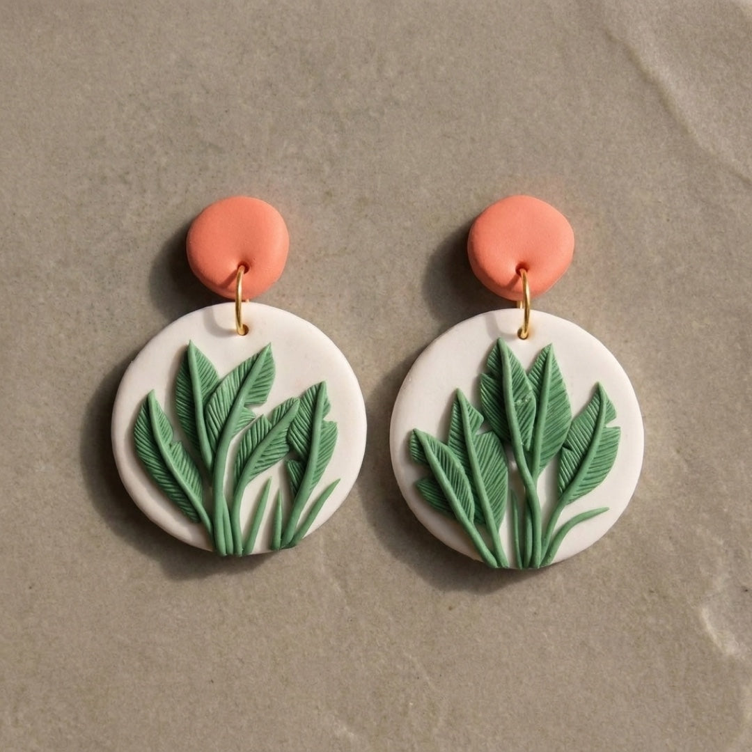 Just Leaves handmade polymer-clay earrings, the pair on a warm stone surface