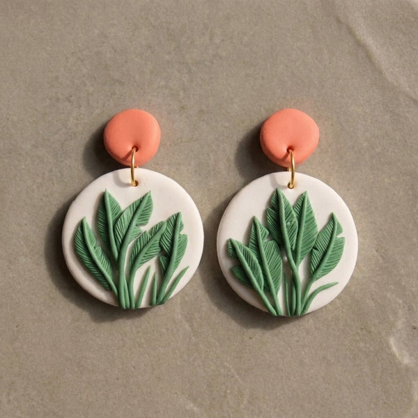 Just Leaves handmade polymer-clay earrings, the pair on a warm stone surface