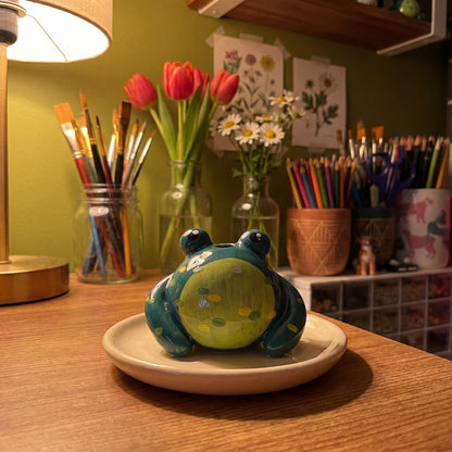 Mr. Ribbit handmade glossy clay desk pal, in the Moon Kiln studio, evening lamp light