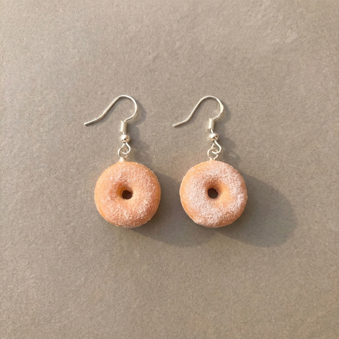 Sugar Donuts handmade polymer-clay earrings, the pair on a warm stone surface