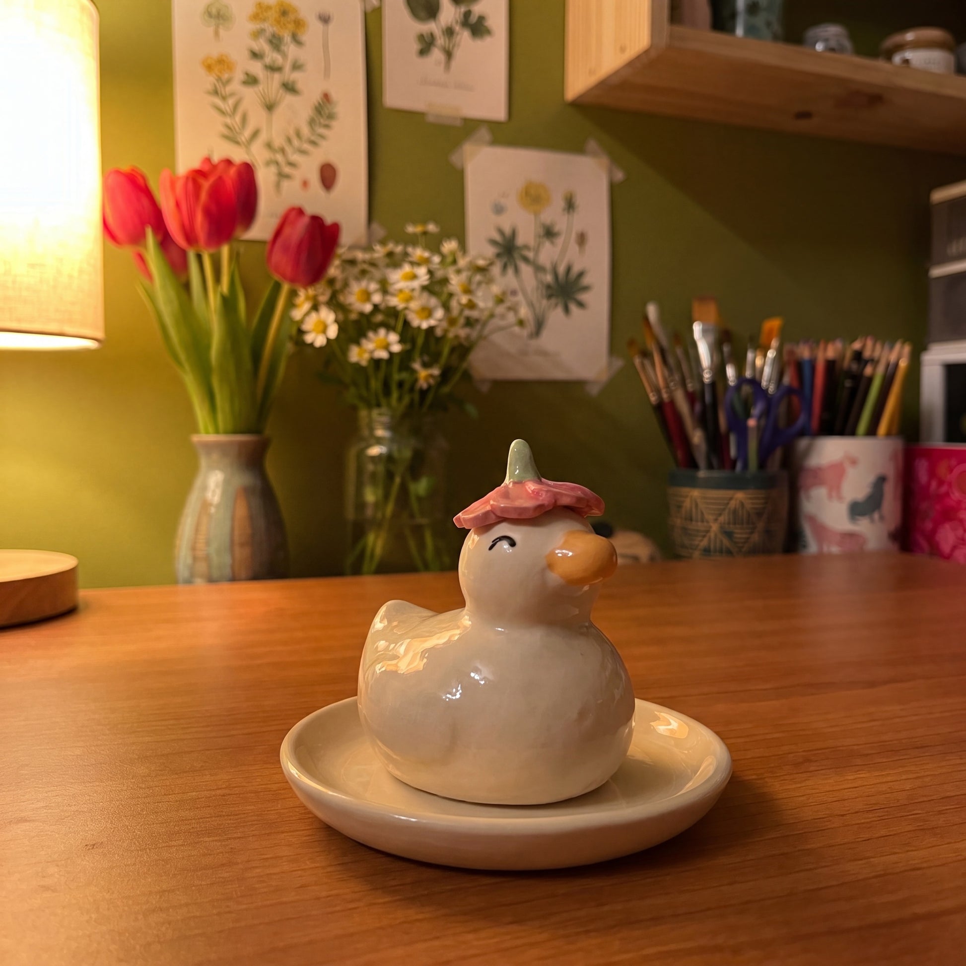 Dreamy Duck handmade glossy clay desk pal, in the Moon Kiln studio, evening lamp light