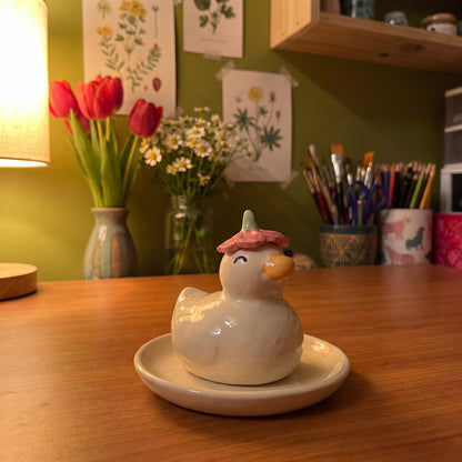 Dreamy Duck handmade glossy clay desk pal, in the Moon Kiln studio, evening lamp light